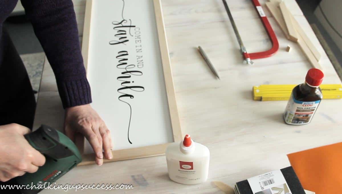 Using a staple gun on the corners of a wooden frame to keep them tight while the wood glue is drying.