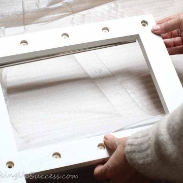 A person holding part of a self-assembly shoe-rack.
