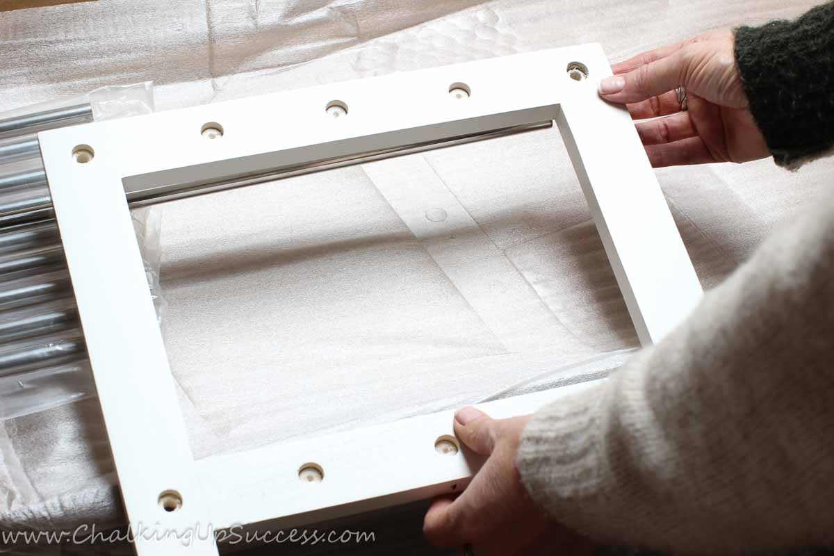 A person holding part of a self-assembly shoe-rack.