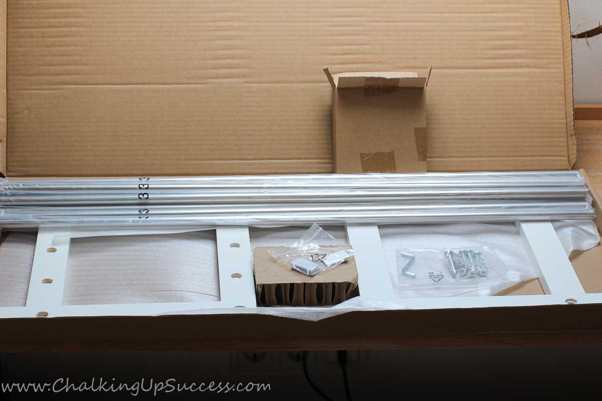 An open box reveals an unassembled closet floor shoe rack.